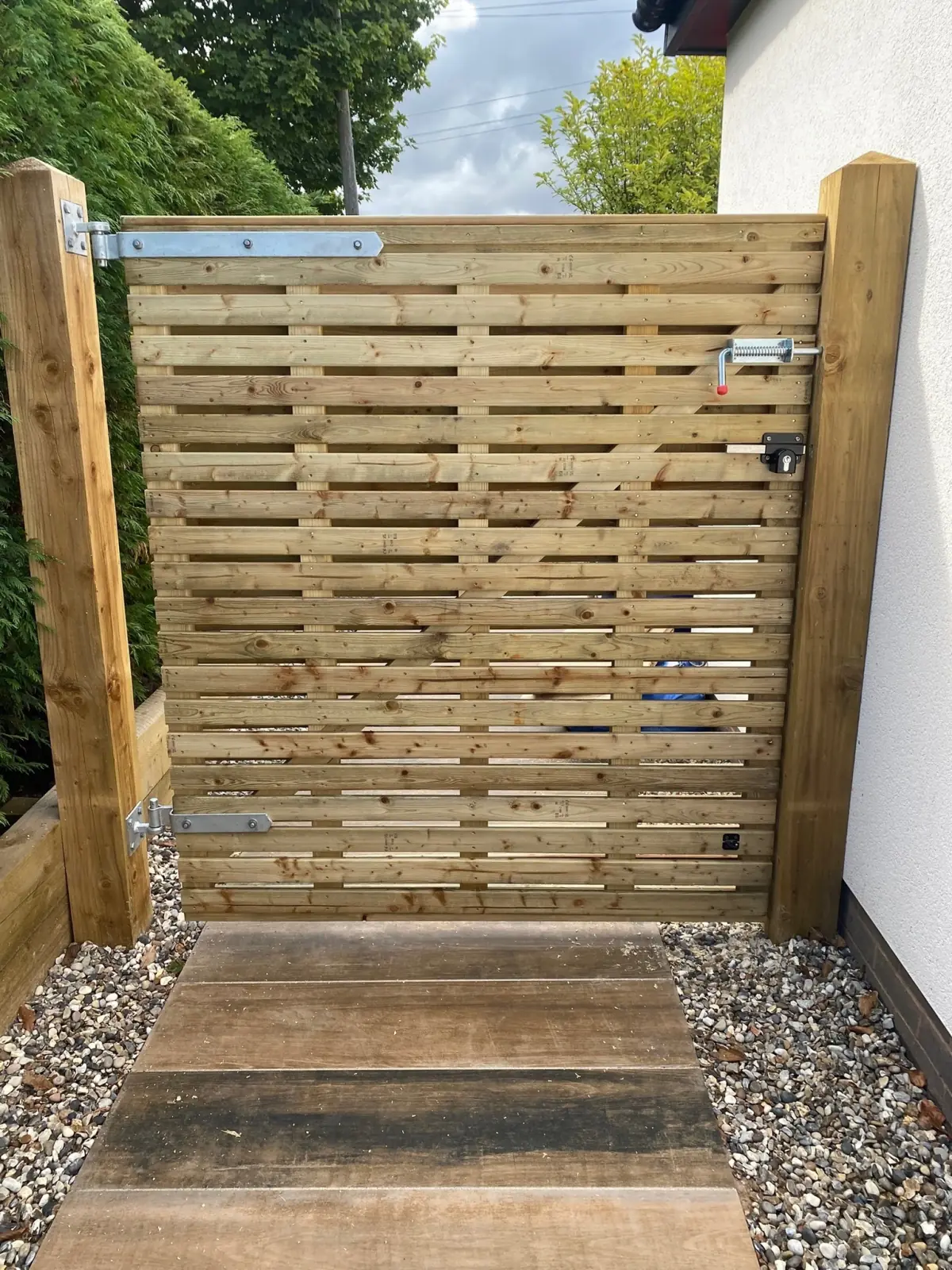 Slatted timber gate hung on planed posts